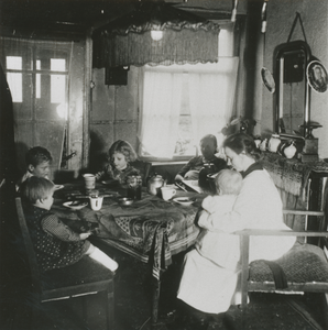 876915 Afbeelding van een Zuster Augustines die als gezinshulp werkt bij een gezin, vermoedelijk in Wijk C te Utrecht.